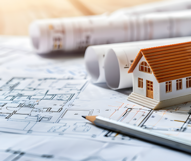 miniature house and gray pencil on a blueprint